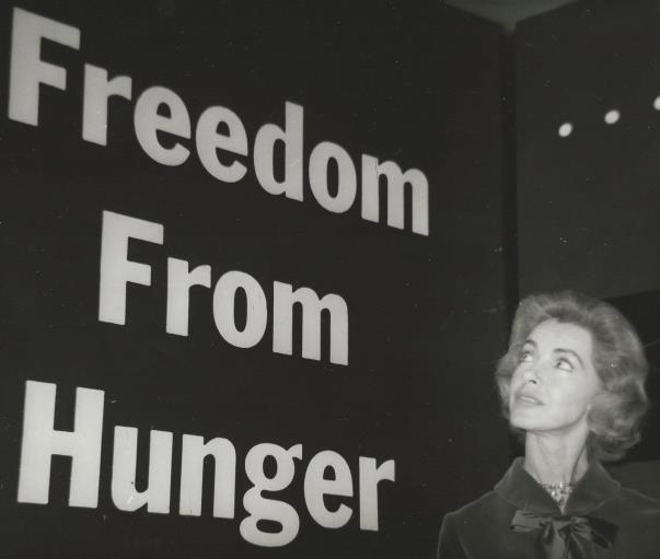 Marsha Hunt in front of a sign for the charity Freedom From Hunger (Photo courtsey of Roger Memos)